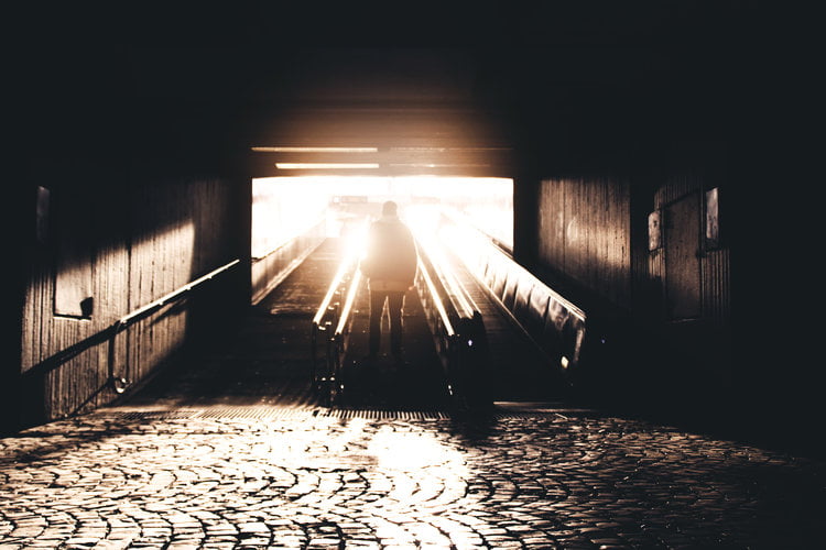 a guy standing in steps with sunrise on him